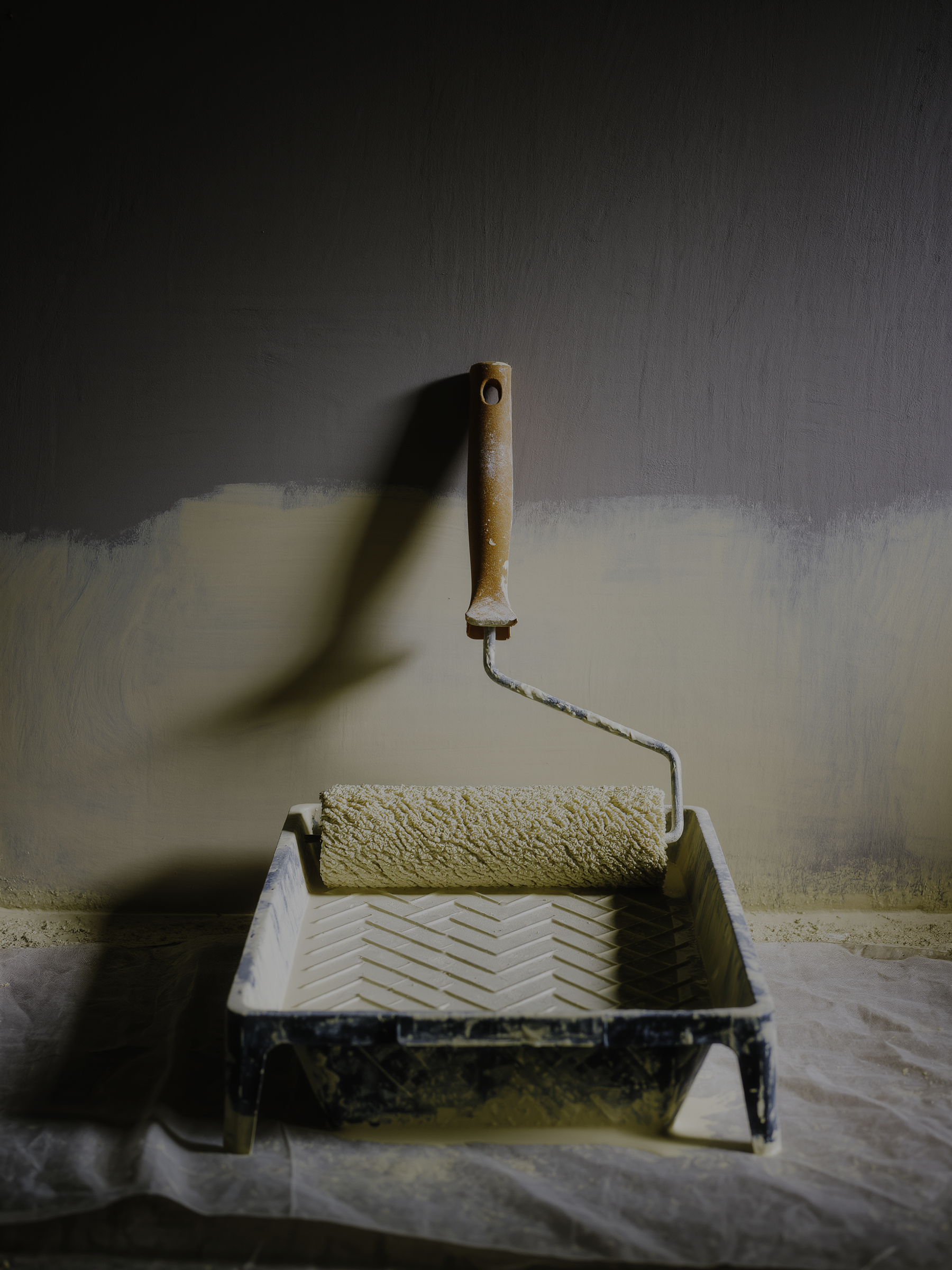 Farbwanne und Malerrolle auf der Baustelle, Detailaufnahme im Hochformat